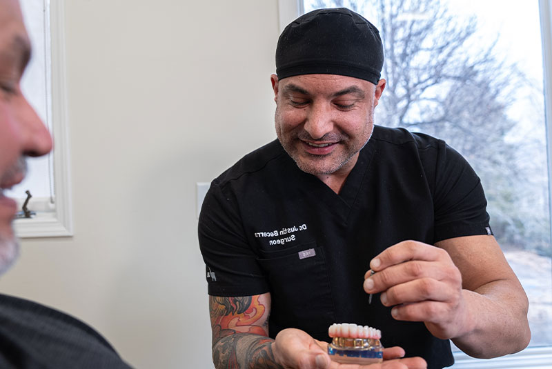 dr with model showing dental patient